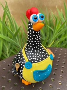 a black and white chicken with polka dots on it's head sitting on a table