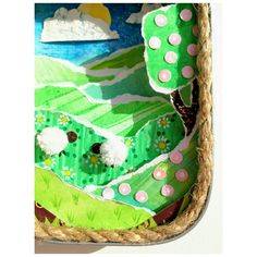 a close up of a cake decorated with grass and flowers on a white wall background