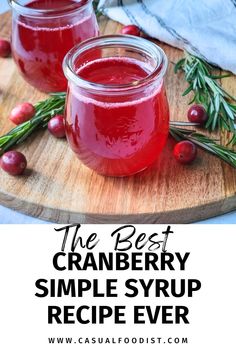 cranberry simple syrup recipe in two jars with rosemary sprigs on the side