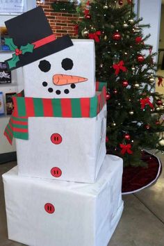 a snowman made out of wrapped presents in front of a christmas tree