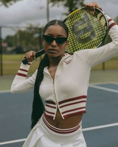 a woman holding a tennis racquet on top of a tennis court