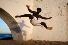 a man in white shirt and shorts jumping into the air