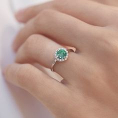 Even the legendary Queen Cleopatra ornamented herself with Emerald. Emerald jewels are traditional presents for 20th and 35th wedding anniversaries, but magical green beauty is great engagement piece too. This ring is crafted at our atelier in white gold with a halo of diamonds. #klenota #klenotajewelry #whitegold #14k #14carat #symboloflove #finejewelry #specialoccasion #jewelrymakers #klenotaring #ring #diamond #emerald #haloring #gemstonering #engagement #anniversarygift Emerald Diamond Ring With Halo For Promise, Emerald Rings With Diamond White Halo Setting, Emerald Diamond Halo Promise Ring, Emerald Halo Diamond Ring For Promise, Formal Emerald Ring With Halo, Formal Emerald Ring With Halo And Round Cut, Diamond Birthstone Ring With Halo Setting, Formal Emerald Halo Ring With Round Cut, Dazzling Emerald Ring With Halo Setting For Promise