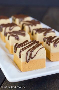 several pieces of cake on a white plate with chocolate drizzled on top