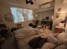 a bed room with a large screen on the wall