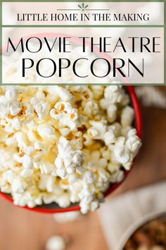 a red bowl filled with popcorn on top of a wooden table