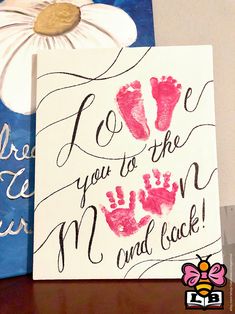 two handprinted cards with flowers on top of each one and the words i love you to the moon and back