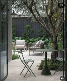 an outdoor patio with chairs, table and trees