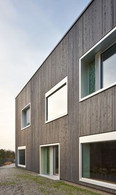 an exterior view of a building with multiple windows on each side and grass in the foreground