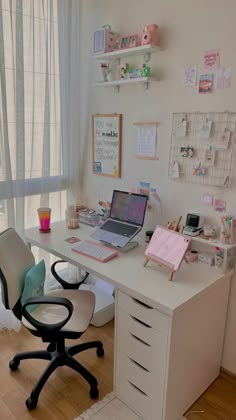 a white desk with a laptop computer sitting on top of it next to a window