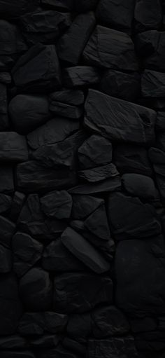 a black rock wall with lots of rocks on it's sides and the bottom