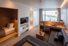 a hotel room with a bed, desk and television in it's corner area