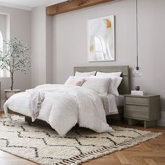 a bedroom with white bedding and wooden floors