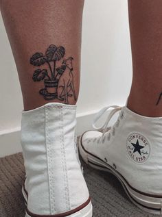 a woman's legs with tattoos on them and white converse shoes in front of her