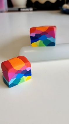 two pieces of colorful candy sitting on top of a white counter next to each other