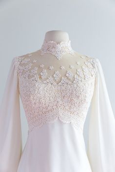 a white dress on a mannequin neckline with long sleeves and beading