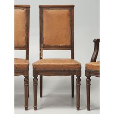 a pair of chairs with leather upholstered back and arms