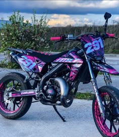 a pink and black dirt bike parked on the street