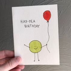 a hand holding up a card with an image of a happy birthday balloon on it