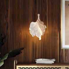 a lamp that is on top of a wooden shelf next to a vase and some books