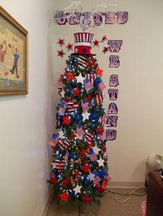 a christmas tree decorated with red, white and blue stars in the shape of an american flag