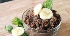 a bowl filled with granola topped with sliced banana slices and green leafy leaves