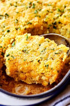 a close up of a spoon in a casserole dish with food on it