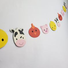 a number of paper animals hanging from a line on a white wall next to each other