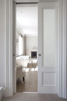 an open door leading to a white living room