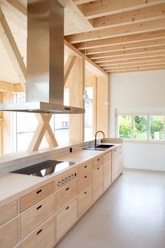 a kitchen with an oven, sink and stove top in the middle of wood paneled walls