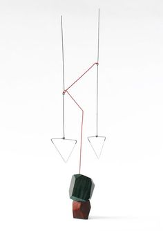 a sculpture made out of wood and wire hanging from it's sides on a white background