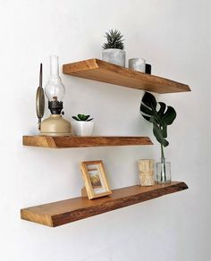 two wooden shelves with plants and pictures on them