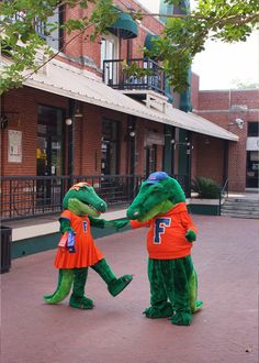 two people dressed as alligators shaking hands