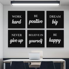 four black and white prints on the wall above a table with two chairs, one laptop computer