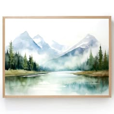 a watercolor painting of mountains and trees on a white wall with a wooden frame