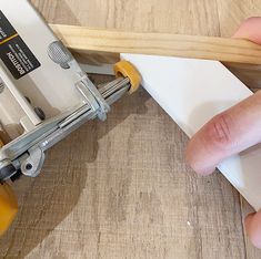 a person using a pair of scissors to cut wood