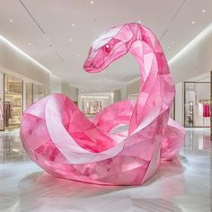 a large pink sculpture in the middle of a room with white flooring and walls