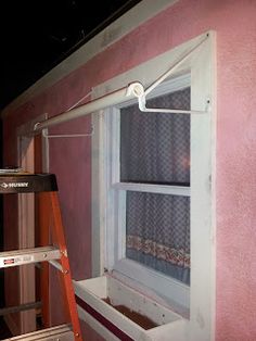 a ladder is next to a window that has been painted pink