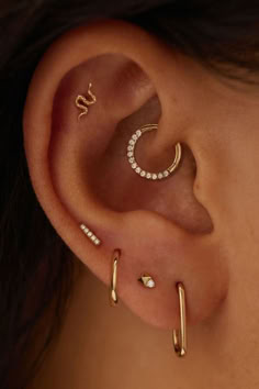 a woman with three different ear piercings on her left side, and one in the middle