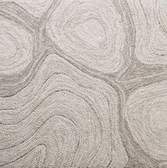 a close up view of an area rug with circles and lines on the ground in grey tones