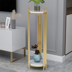 a plant in a vase on top of a stand next to a white table with gold legs