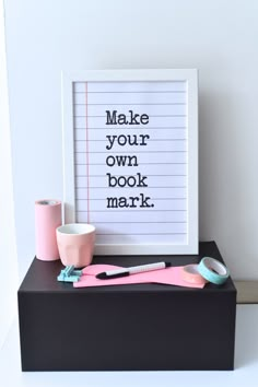 a white framed sign sitting on top of a table next to a cup and toothbrush