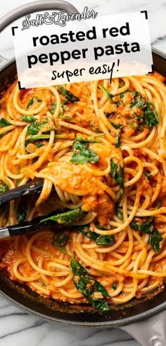 a skillet filled with pasta and spinach on top of a white marble counter