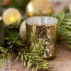 a close up of a candle on a table with christmas decorations in the back ground