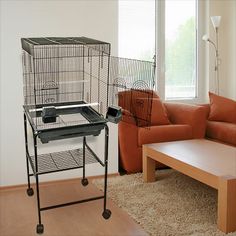 a living room filled with furniture and a bird cage on top of a coffee table