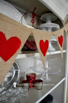 red hearts are hung on burlock over the hutch for valentine's day