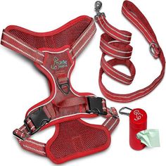 a red dog harness and leash set with matching collars, leads, and an empty bottle on a white background