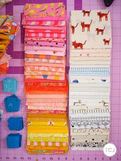 several different types of fabric laid out on a cutting board next to scissors and other crafting supplies