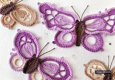 three crocheted butterflies sitting next to each other