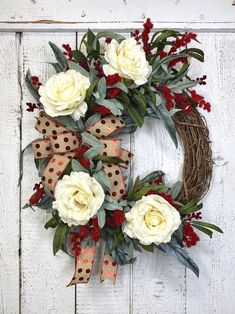 a wreath with white flowers and red berries